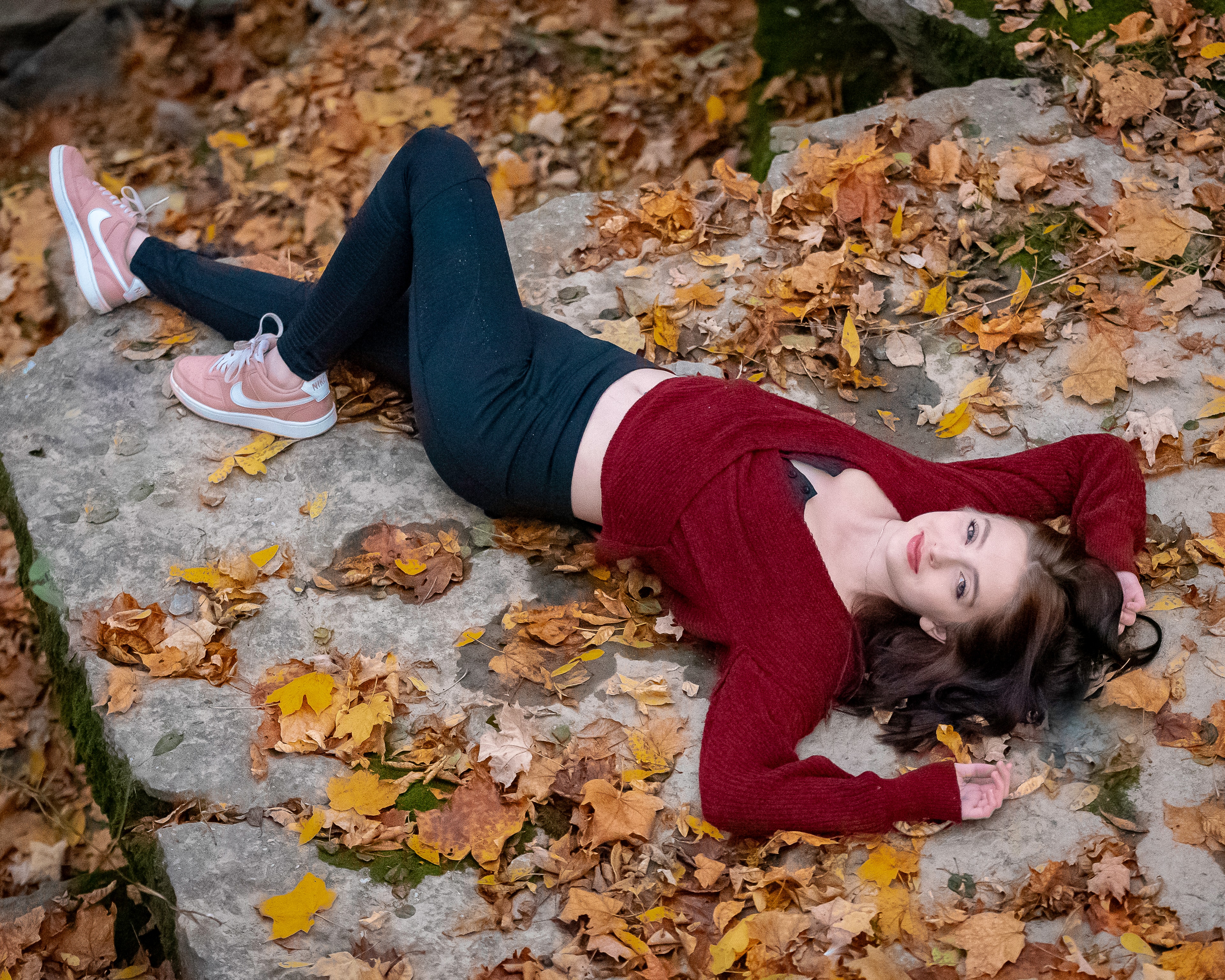 Senior portrait among autumn leaves in warm fall light